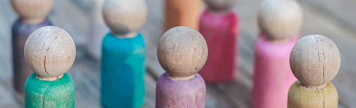 Bunte Holzspielfiguren in einer Gruppe